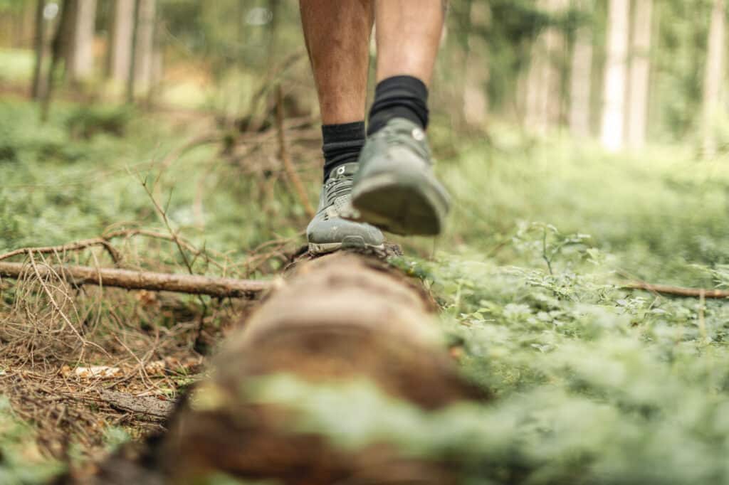 Balancieren auf dem Baumstamm im Wald